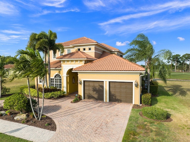 mediterranean / spanish-style home with a garage and a front lawn