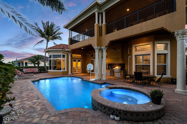 pool at dusk with area for grilling, an in ground hot tub, a patio, and french doors