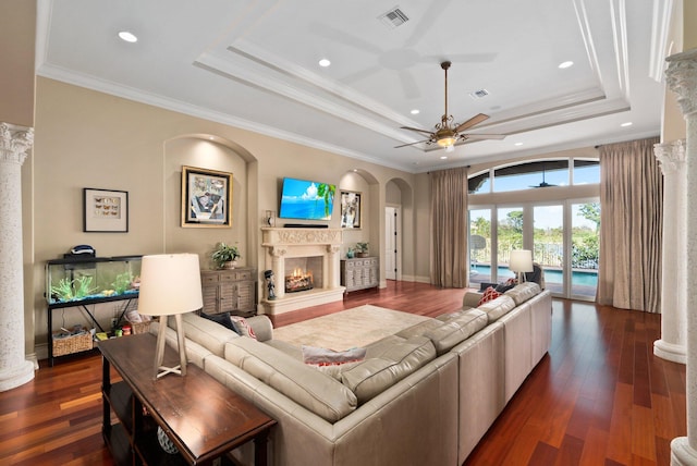 living room with dark hardwood / wood-style floors, a raised ceiling, ceiling fan, and crown molding