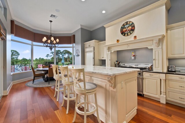 kitchen featuring a center island, hanging light fixtures, a notable chandelier, cream cabinets, and high end appliances