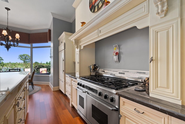 kitchen featuring cream cabinetry, range with two ovens, and hanging light fixtures