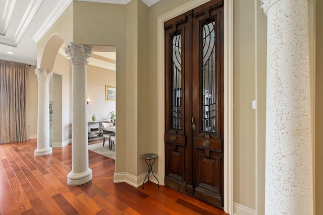 foyer with decorative columns, crown molding, and hardwood / wood-style flooring