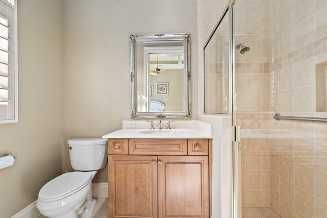 bathroom featuring vanity, a shower with door, tile patterned flooring, ceiling fan, and toilet