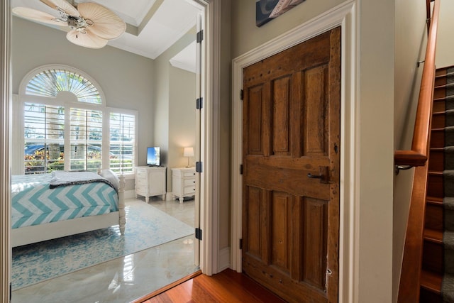 bedroom featuring ceiling fan, crown molding, and wood-type flooring