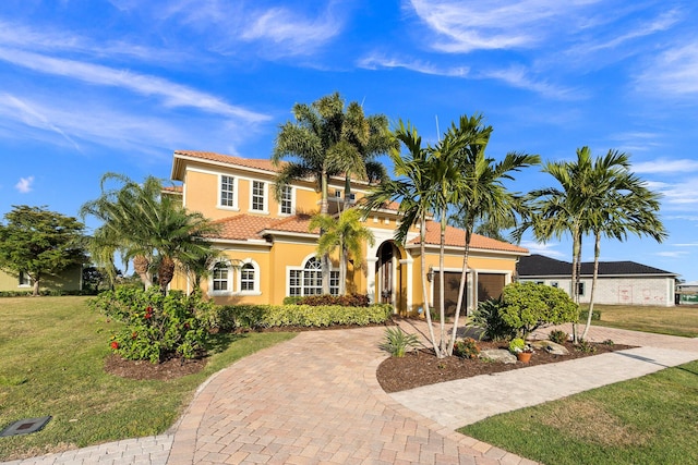 mediterranean / spanish-style house with a front lawn and a garage