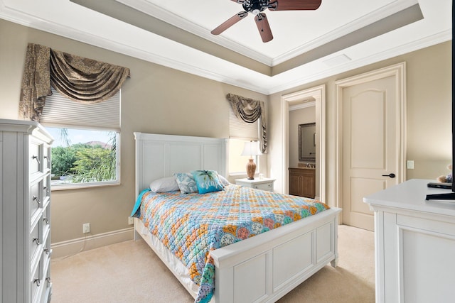 bedroom featuring light colored carpet, ceiling fan, crown molding, and a tray ceiling