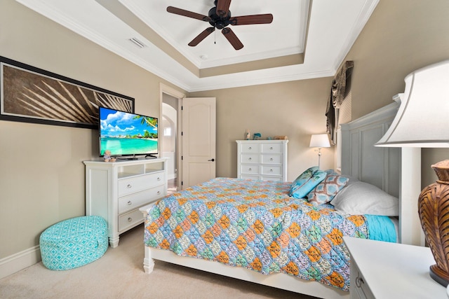 carpeted bedroom with ceiling fan, a raised ceiling, and crown molding