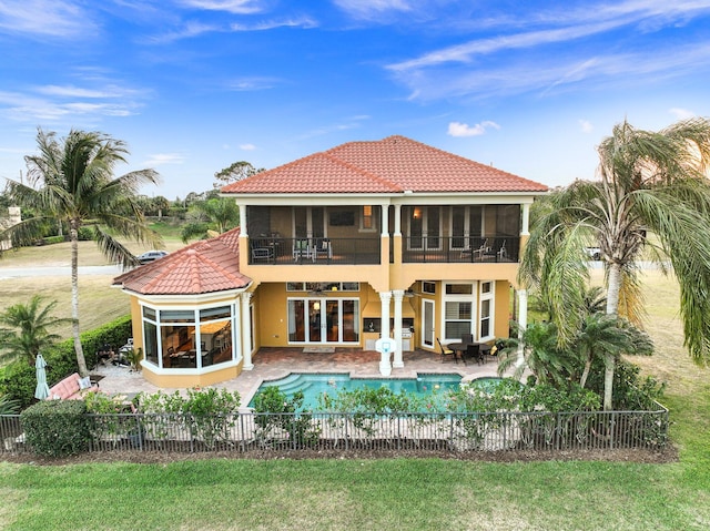 back of house featuring a balcony, a fenced in pool, and a patio