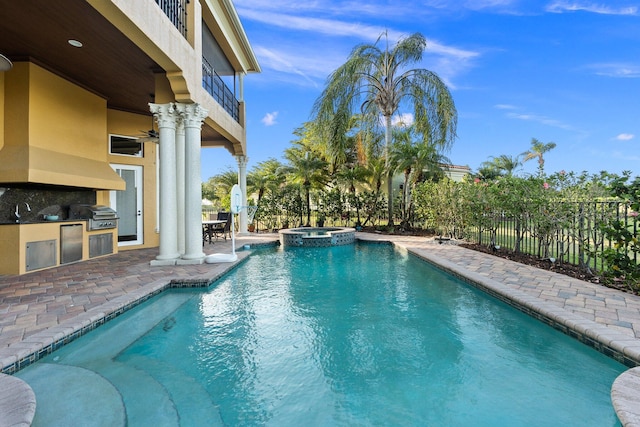 view of pool with an in ground hot tub, area for grilling, sink, a patio area, and a grill