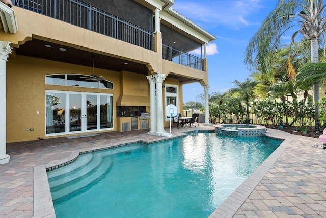 view of swimming pool featuring french doors, an outdoor kitchen, ceiling fan, an in ground hot tub, and a patio