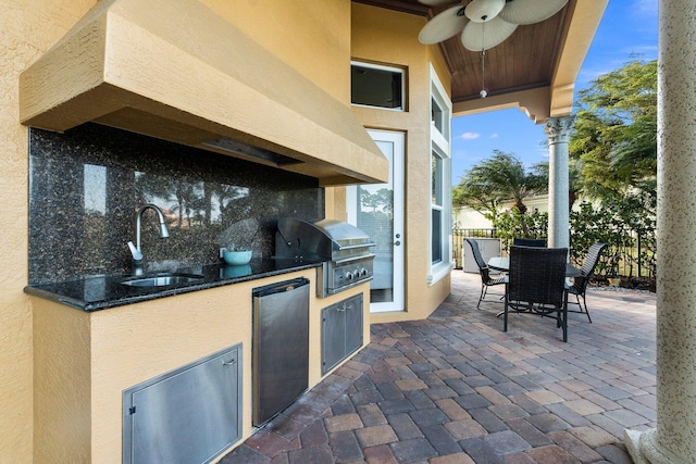 view of patio featuring area for grilling, ceiling fan, sink, and an outdoor kitchen