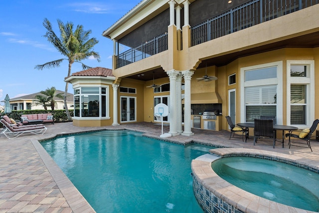 view of swimming pool featuring ceiling fan, an outdoor kitchen, a grill, a patio area, and an in ground hot tub