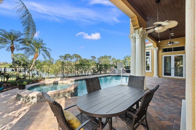 view of patio featuring a swimming pool with hot tub, ceiling fan, and french doors