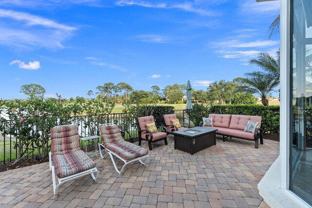 view of patio with an outdoor living space with a fire pit