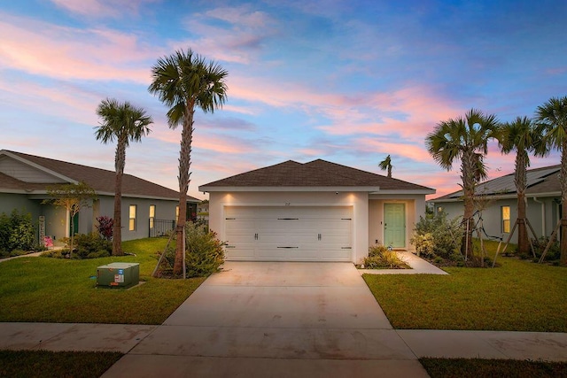 single story home with a garage and a yard