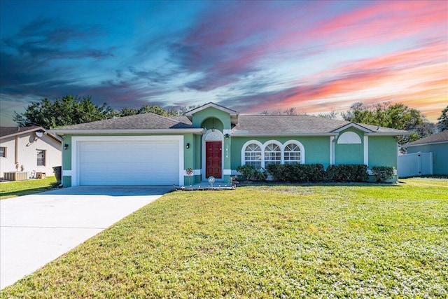 ranch-style house featuring a yard and a garage