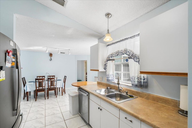 kitchen featuring a textured ceiling, stainless steel appliances, sink, pendant lighting, and white cabinets