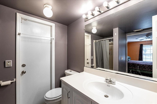 bathroom featuring a shower with shower curtain, vanity, and toilet