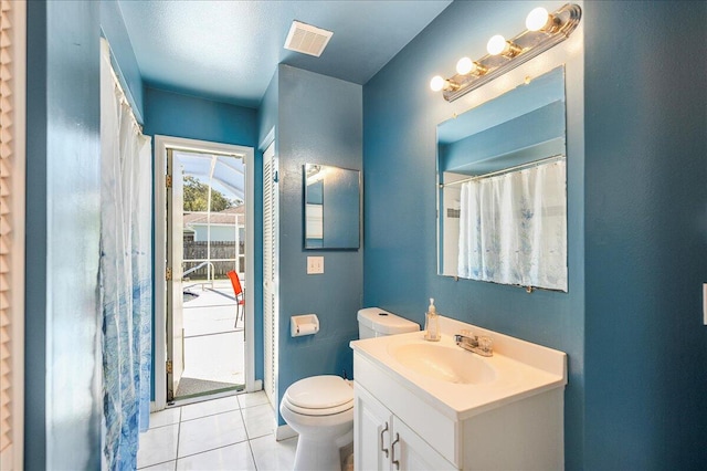 bathroom featuring toilet, vanity, tile patterned floors, and walk in shower