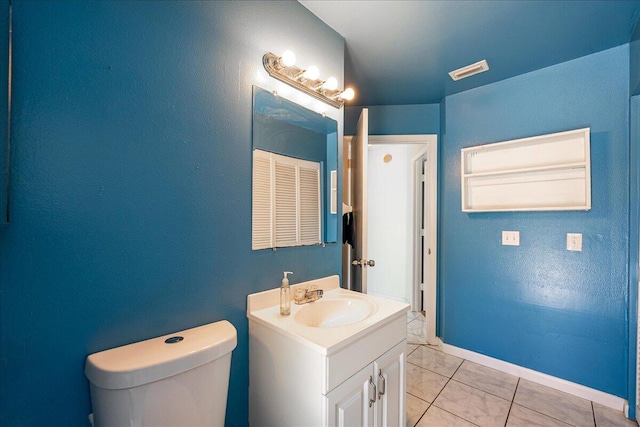 bathroom featuring tile patterned flooring, vanity, and toilet