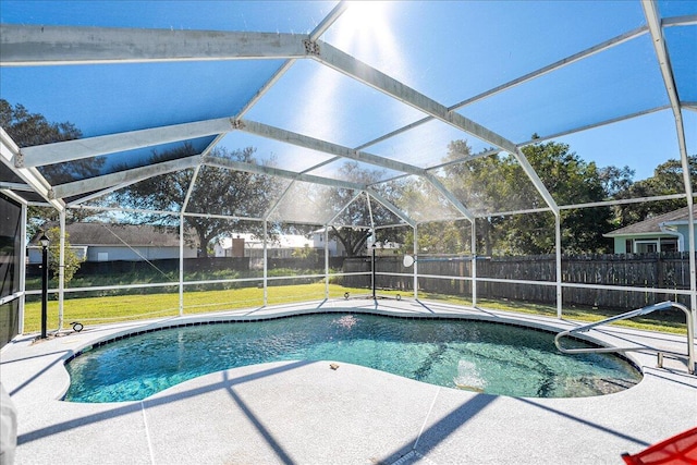 view of pool with a lawn, glass enclosure, and a patio area