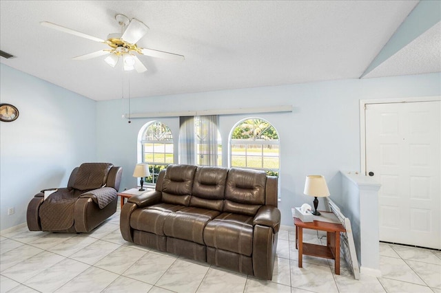 living room with lofted ceiling, ceiling fan, and a textured ceiling