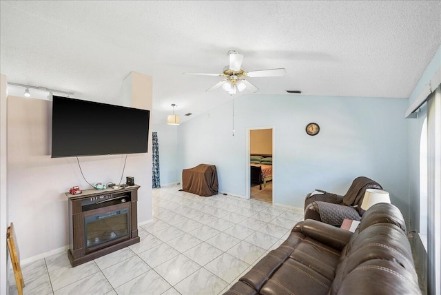 living room featuring a textured ceiling, vaulted ceiling, and ceiling fan