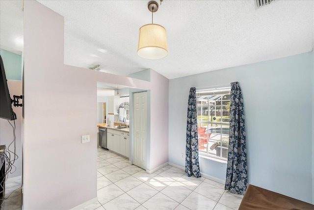 hallway with light tile patterned floors, a textured ceiling, and sink