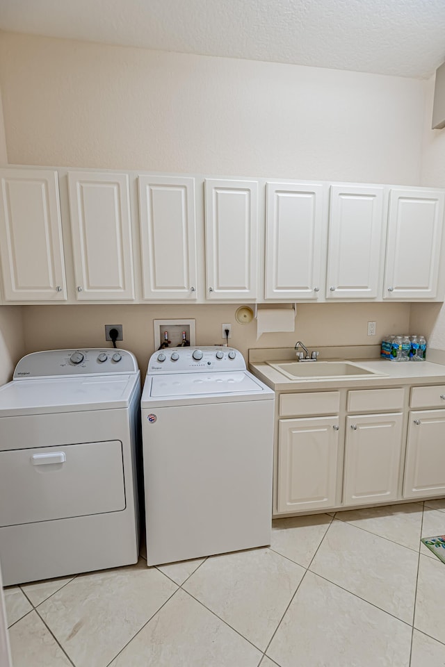 washroom featuring cabinets, separate washer and dryer, sink, and light tile patterned floors