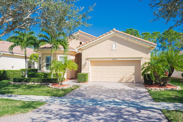 mediterranean / spanish-style house featuring a garage and a front lawn