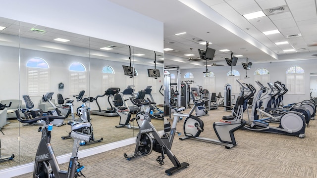 exercise room featuring a paneled ceiling and light carpet