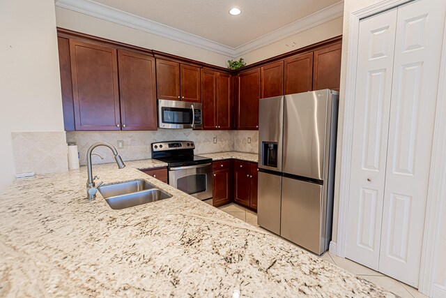 kitchen with appliances with stainless steel finishes, sink, decorative backsplash, light tile patterned floors, and light stone countertops