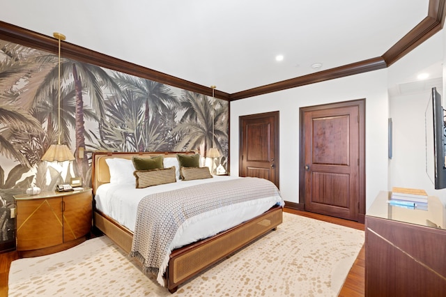 bedroom featuring crown molding and light hardwood / wood-style flooring