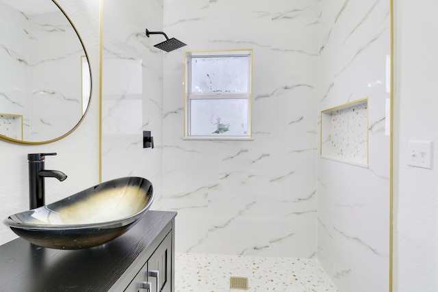 bathroom featuring tiled shower and vanity