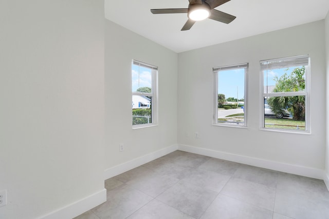 tiled empty room featuring ceiling fan and plenty of natural light