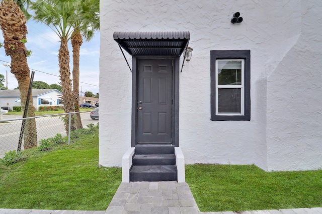 entrance to property featuring a lawn