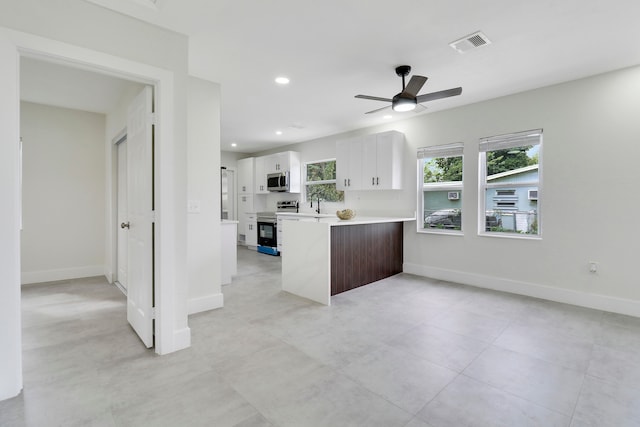 kitchen with ceiling fan, sink, kitchen peninsula, white cabinets, and appliances with stainless steel finishes