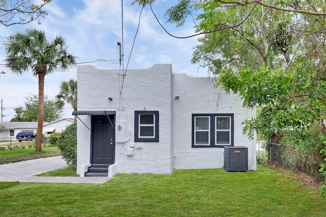 view of front of home with a front lawn and central AC unit