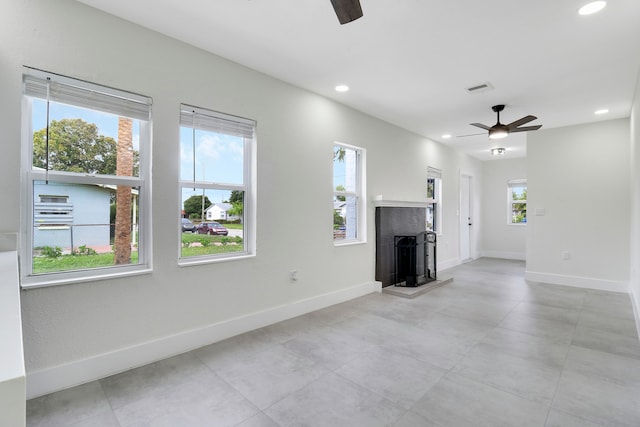 unfurnished living room featuring ceiling fan and a healthy amount of sunlight