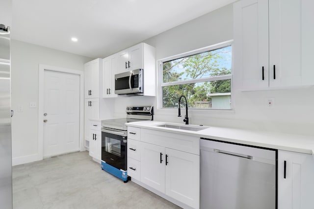 kitchen featuring appliances with stainless steel finishes, white cabinetry, and sink