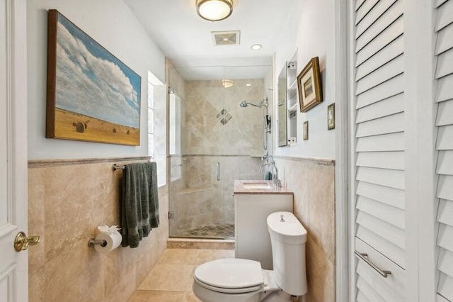 bathroom with walk in shower, tile patterned floors, toilet, and tile walls