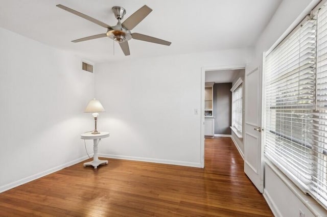 unfurnished room featuring ceiling fan and dark wood-type flooring