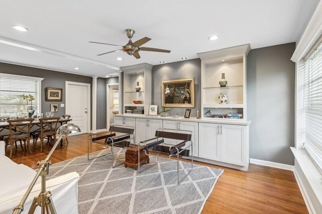 living room with ceiling fan, a healthy amount of sunlight, and light wood-type flooring