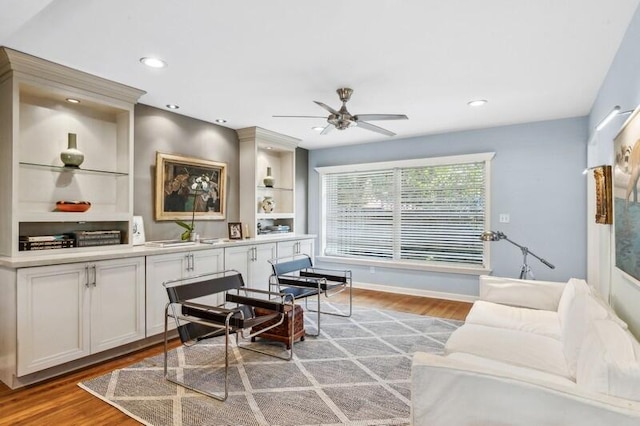 living room with ceiling fan, light wood-type flooring, and sink