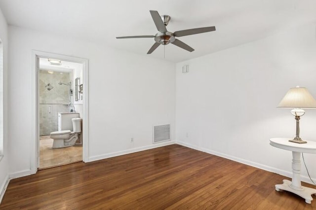 unfurnished bedroom featuring ensuite bathroom, dark hardwood / wood-style flooring, and ceiling fan