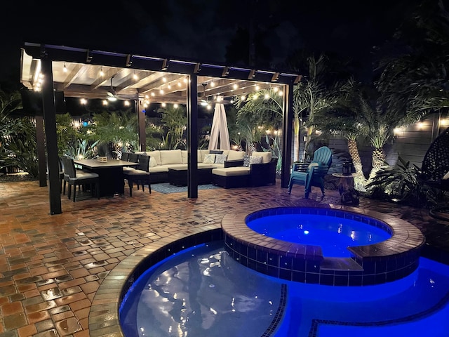 pool at twilight featuring an in ground hot tub, a patio, and an outdoor hangout area