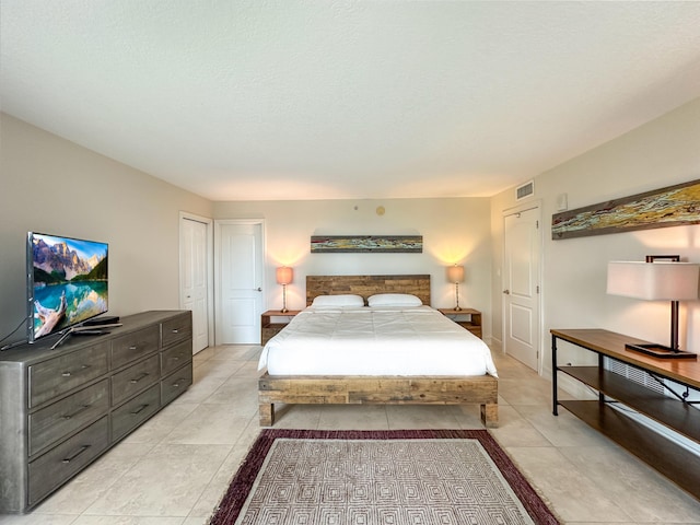 bedroom featuring light tile patterned floors and a textured ceiling