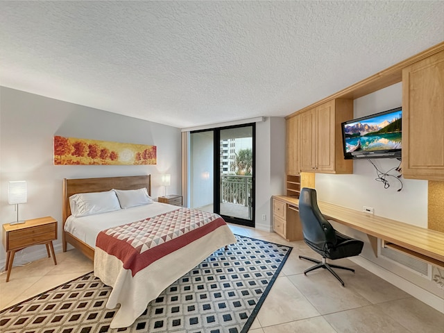 bedroom with access to exterior, light tile patterned flooring, built in desk, and a textured ceiling