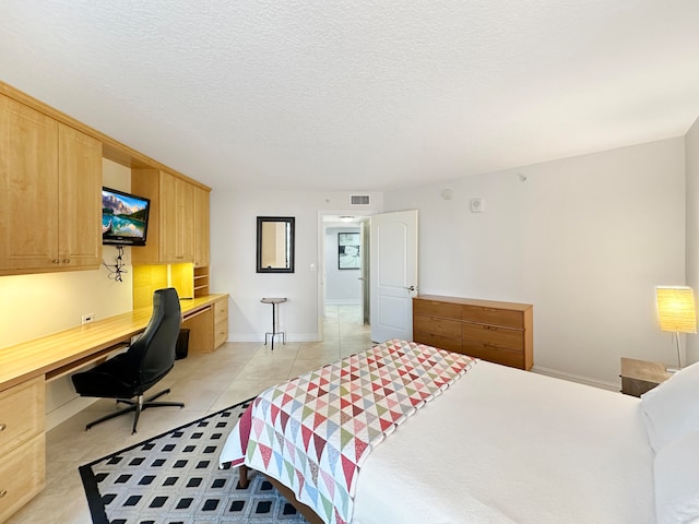 tiled bedroom with built in desk and a textured ceiling