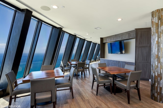 dining space featuring hardwood / wood-style floors, a water view, and a wealth of natural light